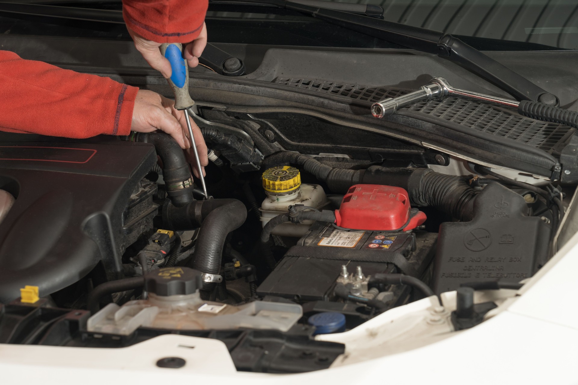 Closeup shot of a mechanic working on vehicle engines in a mechanical garage.